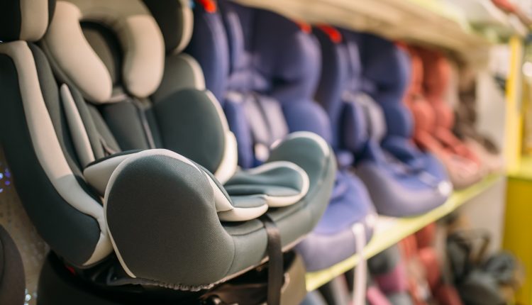 Child car seats variety on shelf in store, nobody